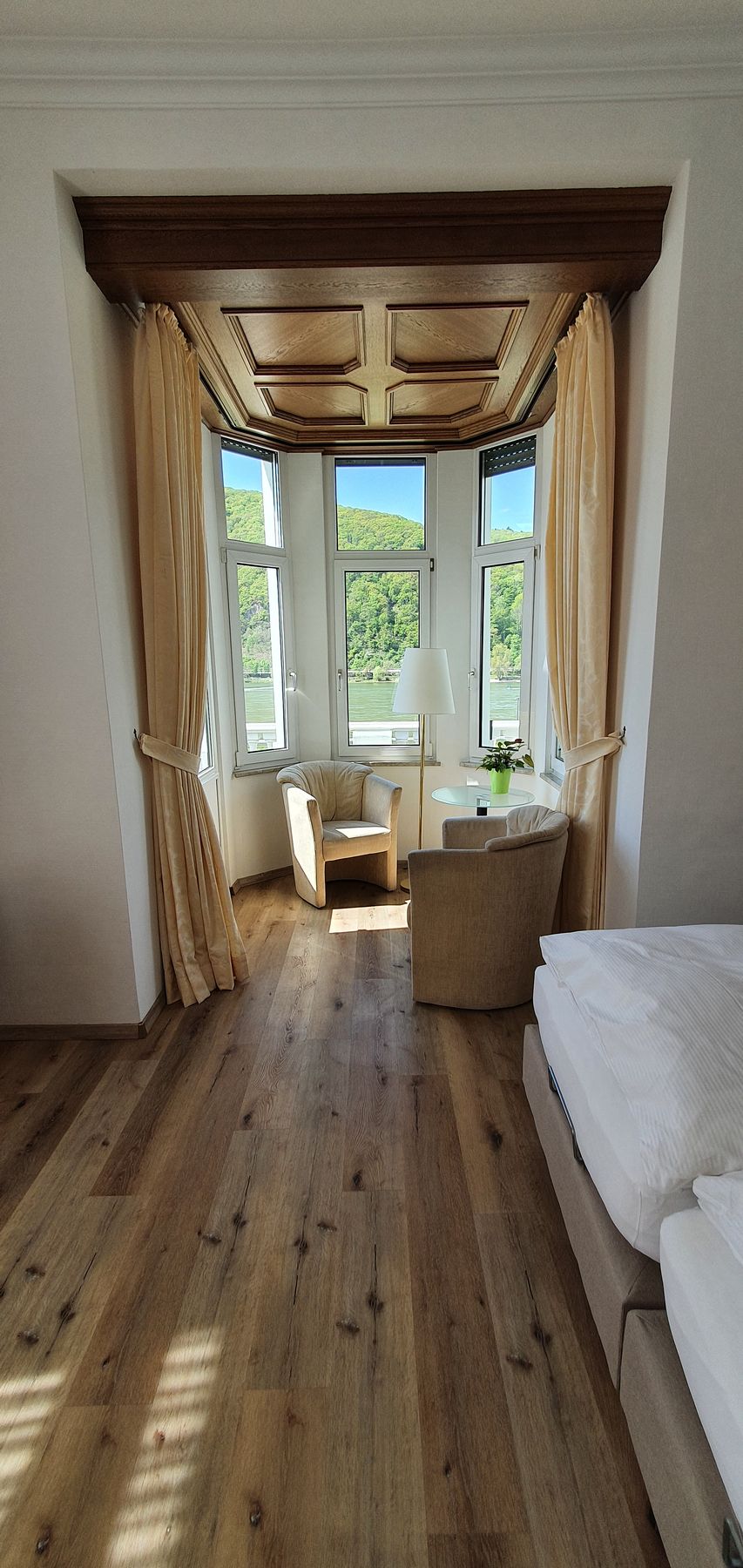 Blick durch das Zimmer auf den Erker mit Fenstern zum Rhein