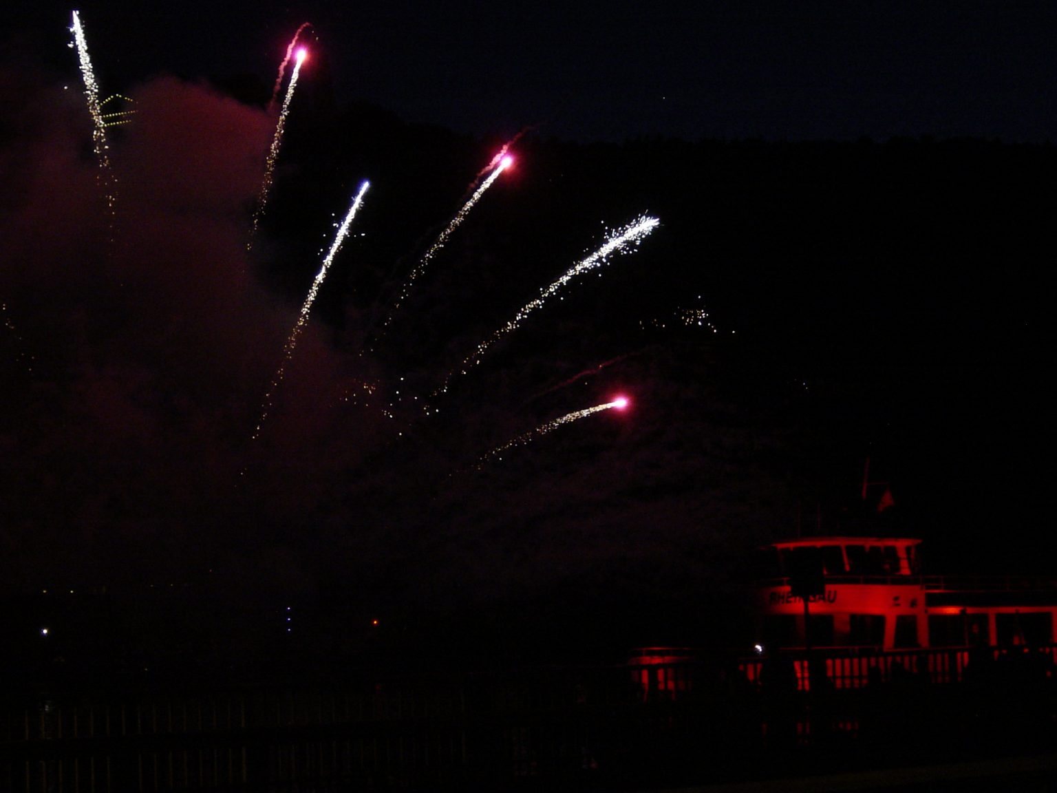 Feuerwerk über dem Rhein, davor die rot beleuchtete Rheingau der Rössler-Linie
