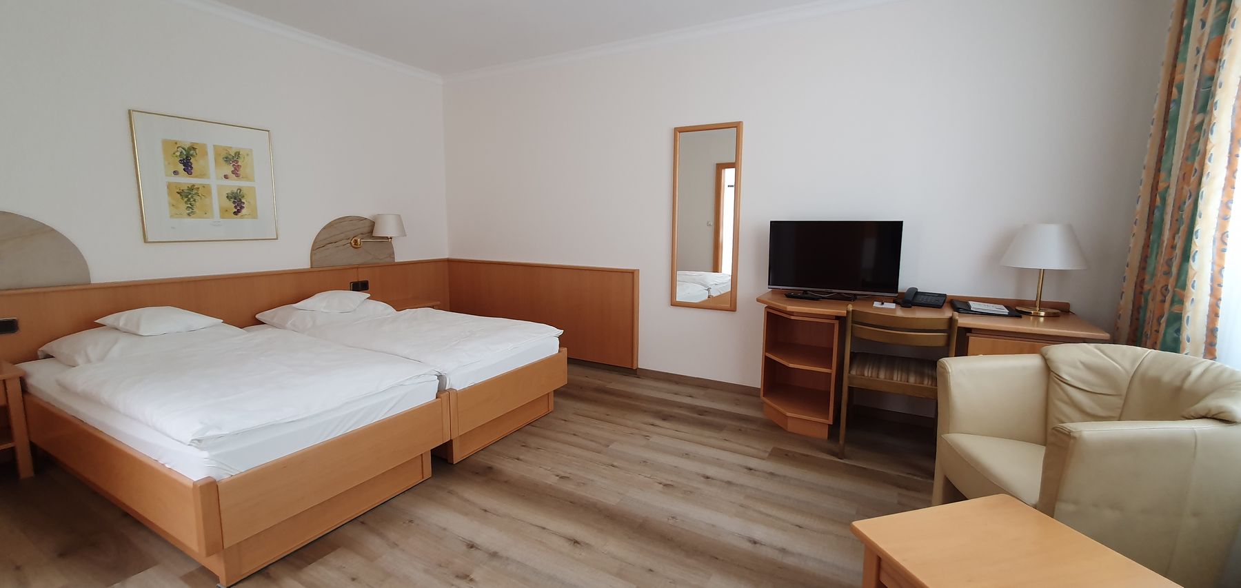 Zimmer mit zwei Einzelbetten, Parkettboden, Sessel und Schreibtisch