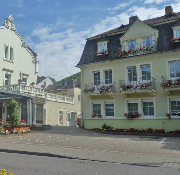 Das Gästehaus mit Blumenkästen an den Balkonen, links daneben das Haupthaus